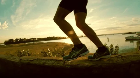 The legs of a man runner - have jogging in park at sunset, close-up, slow-motion Stock Footage 87479821