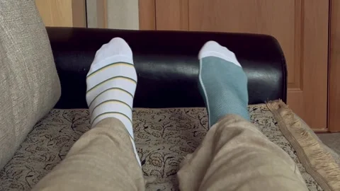 Legs of a man in socks of different patterns. Stock Footage 254726561