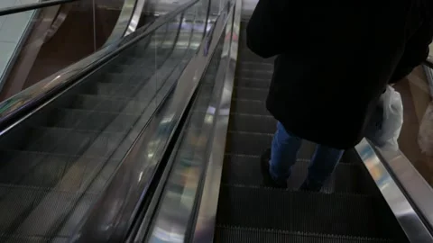 Legs of a man standing on an escalator going down. Stock Footage 306372808