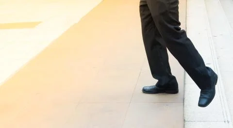 Legs of man step up from steps and forward to space Stock Photos
