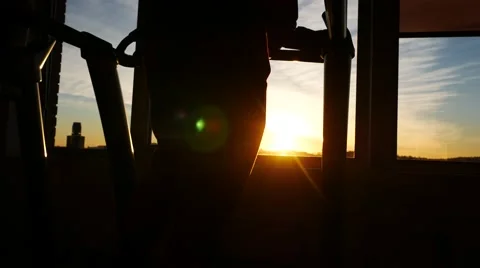 Legs of the man training on a treadmill. Sunset sky beyond the window 스톡 동영상 65530510