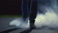 The legs of a man walking near the cloud of a smoke. slow motion 4k or 4k+ Resolution