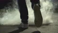 The legs of a man walking near a cloud of smoke. evening night time, slow motion 4k or 4k+ Resolution