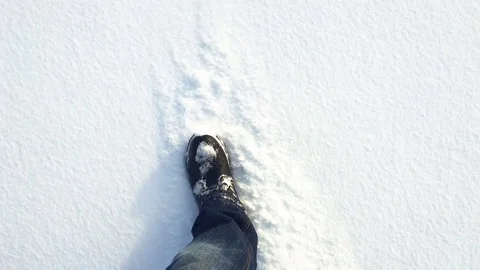 The legs of a man walking on white fluffy snow Stock Footage 85318378