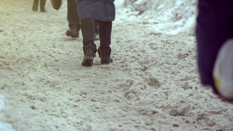 Legs of People Walking On A Snowy Sidewalk Stock Footage