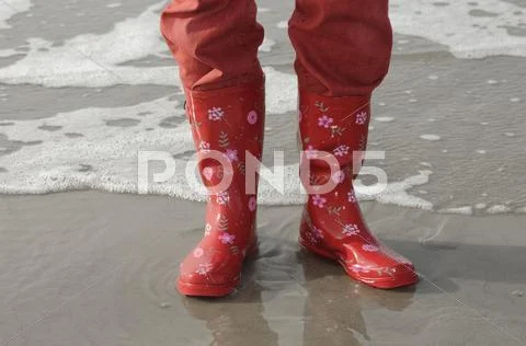 Legs With Red Pants And Red Rubber Boots On The North Sea Beach, Vejer Beach,