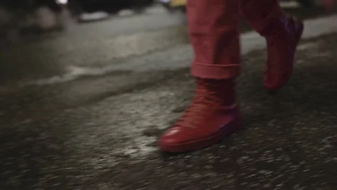 Legs in red pants walks through the city at night on the asphalt.  Stock Footage 102437684