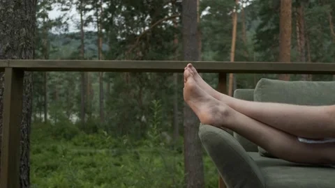 Legs of a resting man on the couch against the background of the forest Video stock 154278182