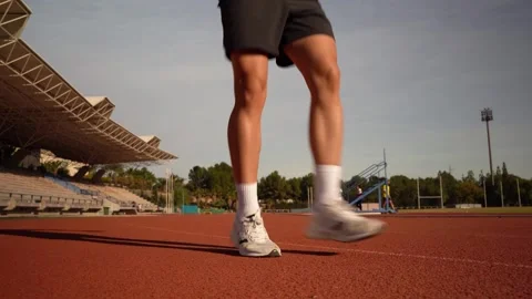 Legs of a runner doing jumps as a warm-up on an athletics track. Training a.. Stock Footage 267894510