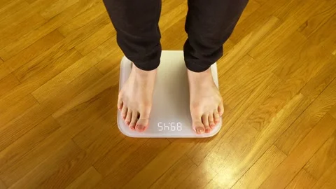 Legs on the scales. Man checking his weight. Video stock 143593437