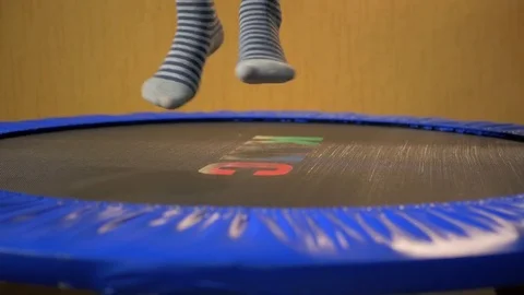 Legs in striped socks jumping on a trampoline, close-up Stock Footage 72861591