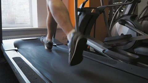 Legs of unrecognizable man running on the treadmill in the fitness studio. Close 스톡 동영상 101878562
