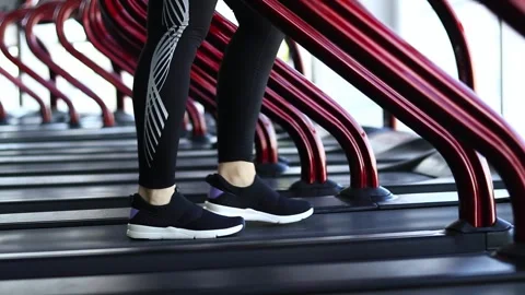 Legs walking on the treadmill at a slow pace, close-up Stock Footage 283388266
