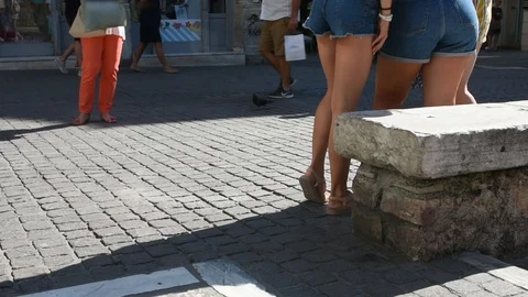 Legs of a woman while she is taking photos of three young girls Stock Footage 113012879