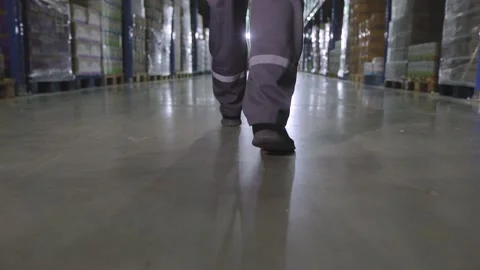 Legs of a worker walking in a warehouse close-up slow motion. A worker walks Видео 203716260