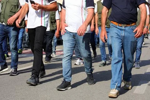 Legs of workers are marching through the streets in a peaceful protest to i.. Фото