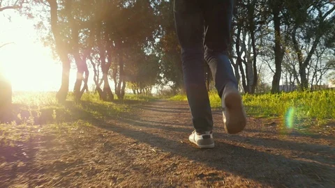 Legs of young happy guy dancing in the beautiful park at sunset in slow Видео 106731478