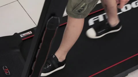 Legs of a young man go on a treadmill doing sports Stock Footage 201793883
