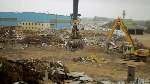 Leipzig, Germany - 07/12/2019: Claw crane at a scrapyard lifting metal Stock Footage 263647301
