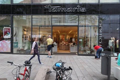 LEIPZIG, GERMANY - MAY 9, 2018: People walk by Tamaris shoe store at Grimmais Stock Photos