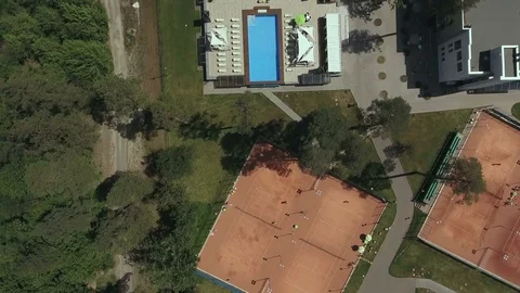 Leisure area with tennis courts and swimming pool from above Stock Footage