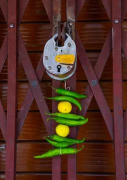 Lemon and green chilli tied on a thread hung outside a door to keep away Alak Stock Photos