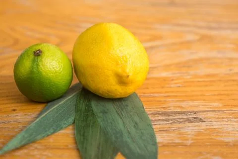 Lemon and lime lie on a wooden stand Stock Photos