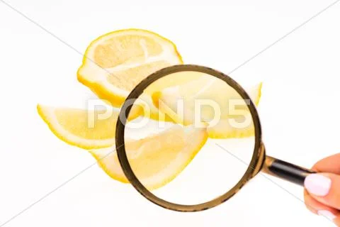 Lemon and a magnifying glass on white background Stock Photos