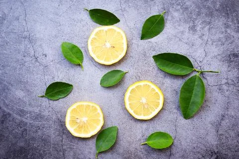 Lemon background / Seamless lemon slice and green leaf on dark Stock Photos