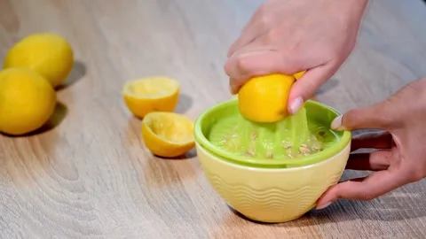 Lemon being pressed and juice squeezed out in real time with fruit in Stock-Footage 336588626