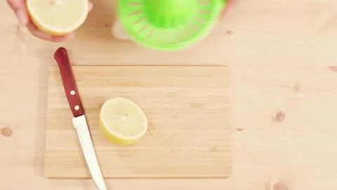 Lemon being pressed and juice squeezed out in real time with fruit in Stock-Footage 336588720