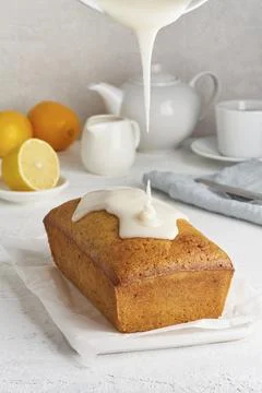 Lemon bread. Process of coating with sugar sweet glaze, stream of glaze flows. Stock Photos