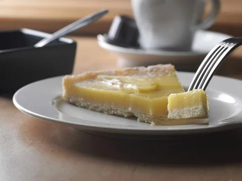 Lemon cake with for and coffee in background 스톡 사진