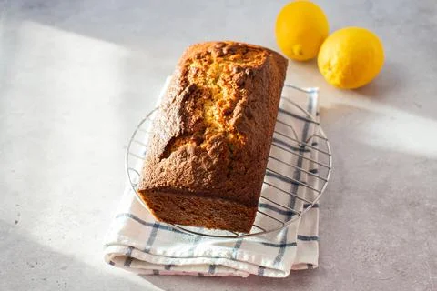 Lemon cake on a cooling rack on a gray background. Stock Photos