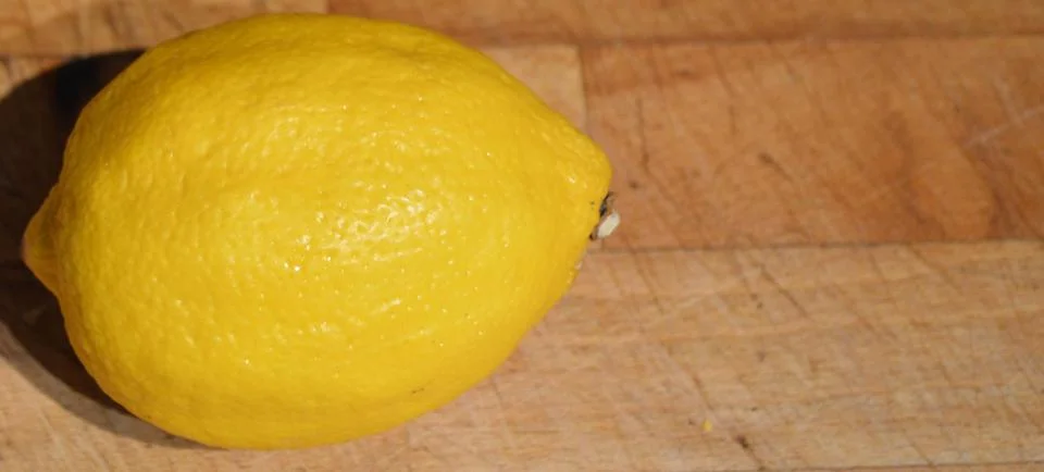 Lemon on a chopping board - space for text on right Stock Photos