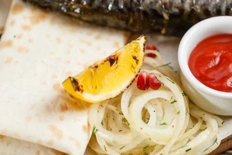 Lemon close-up. grilled mackerel. Serving on a wooden Board on a rustic table Stock Photos