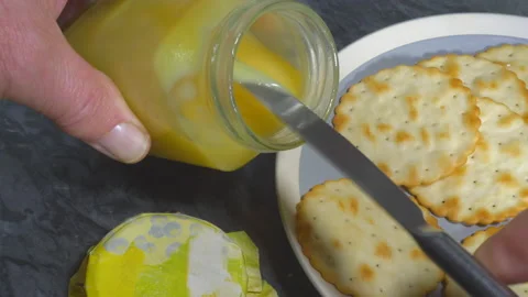 Lemon curd from jar to cracker with knife. Stock Footage 134640225