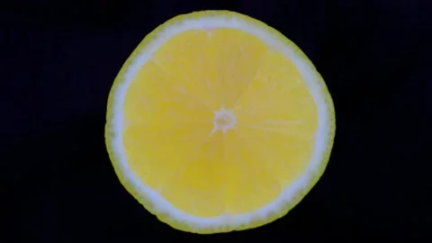 Lemon cut in half rotates on a dark background Stock Footage 147675713