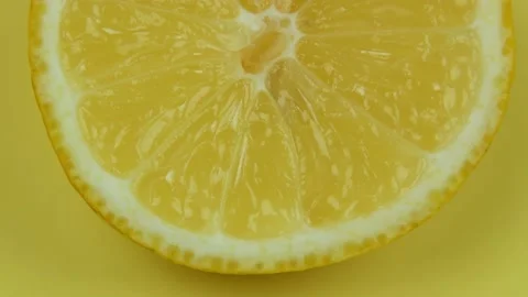 Lemon cut in half rotates on a yellow background Stock-Footage 138894895