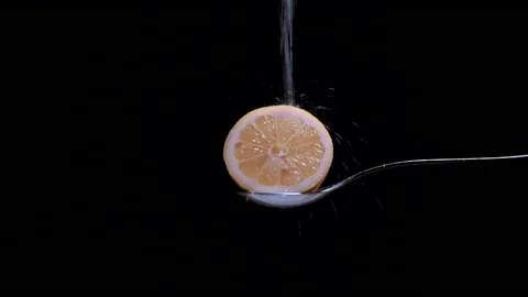 Lemon cut in half viewed close up falling slow sugar Stock Footage 131406237
