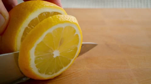 Lemon is cut with a knife. Close-up. Video stock 279418221