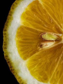Lemon cut. Lemon slice with seed on a black background. Stock Photos