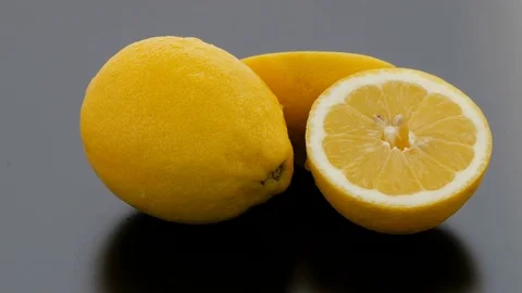 Lemon Cut on Turntables - Black Background - Wet Stock Footage 75855163