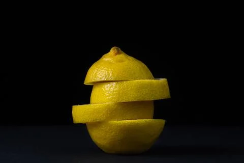 Lemon on a dark background. Sliced lemon on a black background. Stock Photos