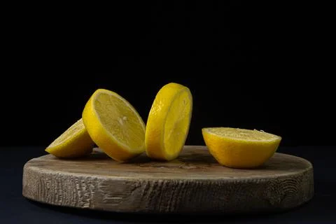 Lemon on a dark background. Sliced lemon on a black background. Creative photo o Stock Photos