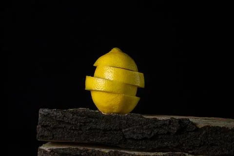 Lemon on a dark background. Sliced lemon on a black background. Stock Photos