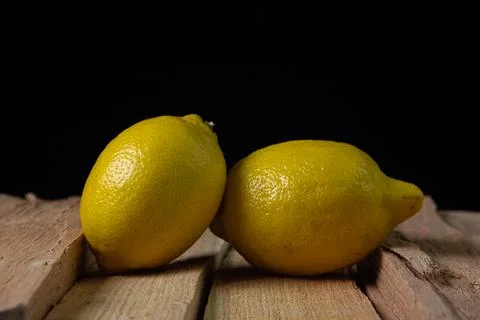 Lemon on a dark background. Two lemons on a wooden background.  Stock Photos