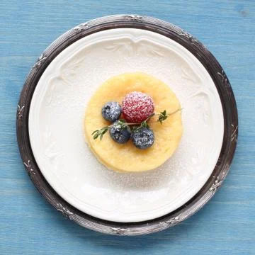 Lemon delicious pudding cake served with berries Stock Photos