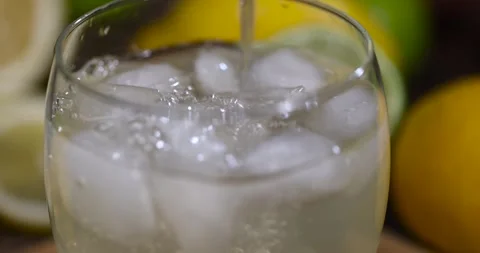Lemon drink with the addition of pieces of pure ice in a glass, sweet and sour Stock Footage 322037366