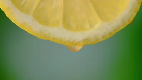 Lemon with dripping clear juice on green background Vidéo 248782854